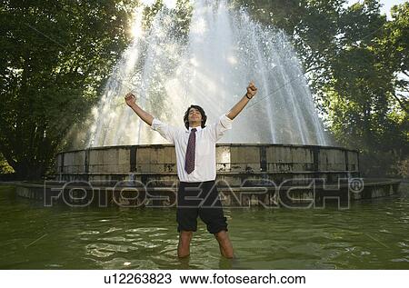 Excited businessman standing in fountain. View Large Photo Image Stock Image - Excited businessman standing in fountain.. Fotosearch