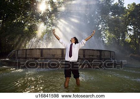 Stock Photo - Excited businessman standing in fountain.. Fotosearch