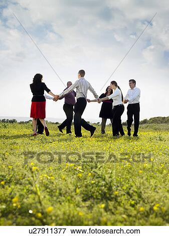 Stock Photo - Group of businesspeople in a field.. Fotosearch