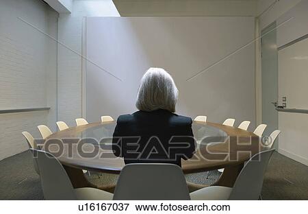 Stock Photo - Woman seated in boardroom from behind. Fotosearch