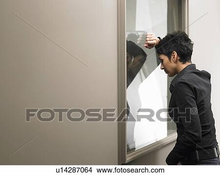 Businesswoman leaning against window in office View Large Photo Image Picture - Businesswoman leaning against window in office. Fotosearch