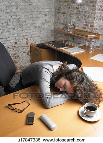 Businesswoman sleeping on desk. Brussels, Belgium. View Large Photo Image Stock Photograph - Businesswoman sleeping on desk. Brussels, Belgium.. Fotosearch