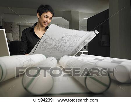 Female architect reading blueprint at desk. Brussels, Belgium. View Large Photo Image Stock Image - Female architect reading blueprint at desk. Brussels, Belgium.. Fotosearch