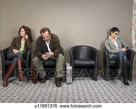 Two businesswomen and a businessman sitting in waiting room. Brussels, Belgium. View Large Photo Image Stock Photograph - Two businesswomen and a businessman sitting in waiting room. Brussels, Belgium.. Fotosearch