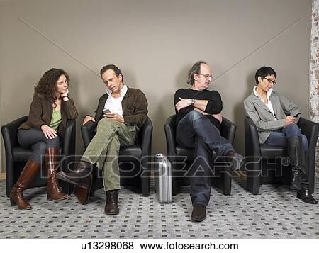 Two businesswomen and two businessmen sitting in waiting room. Brussels, Belgium. View Large Photo Image Stock Photo - Two businesswomen and two businessmen sitting in waiting room. Brussels, Belgium.. Fotosearch
