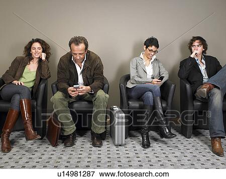 Stock Photo - Two businesswomen and two businessmen sitting in waiting room. Brussels, Belgium.. Fotosearch