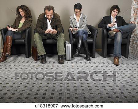 Stock Photo - Two businesswomen and two businessmen sitting in waiting room. Brussels, Belgium.. Fotosearch
