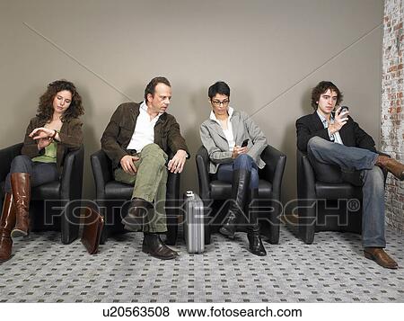 Stock Photo - Two businesswomen and two businessmen sitting in waiting room. Brussels, Belgium.. Fotosearch
