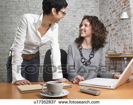 Stock Photo - Two businesswomen laughing., Brussels, Belgium.. Fotosearch
