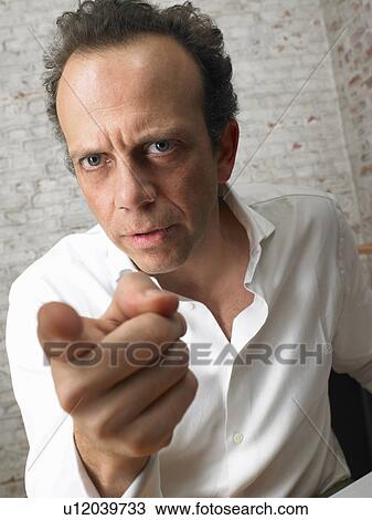 Stock Image - Businessman on the phone pointing at camera., Brussels, Belgium.. Fotosearch