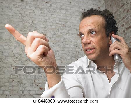 Businessman talking on the telephone, pointing finger., Brussels, Belgium. View Large Photo Image Stock Image - Businessman talking on the telephone, pointing finger., Brussels, Belgium.. Fotosearch