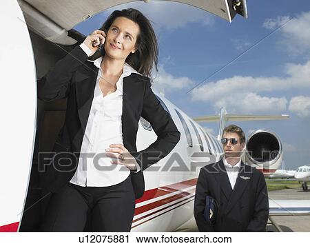 Businesswoman outside of jet in front of pilot. View Large Photo Image Stock Image - Businesswoman outside of jet in front of pilot.. Fotosearch