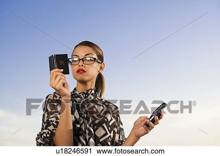 Woman holding cellular phone and small notebook outdoors. View Large Photo Image Stock Image - Woman holding cellular phone and small notebook outdoors.. Fotosearch
