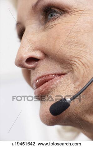 Woman smiling on headset View Large Photo Image Stock Image - Woman smiling on headset. Fotosearch