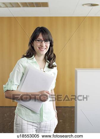 Stock Photography - Young businesswoman in office, portrait, smiling. Fotosearch