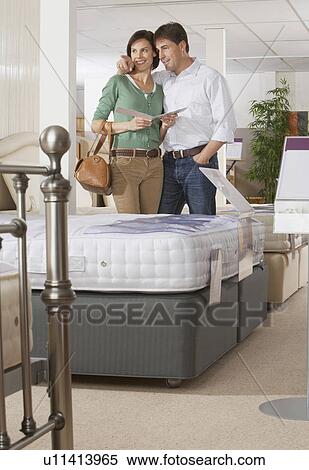 Couple looking at beds in a store. View Large Photo Image Stock Photography - Couple looking at beds in a store.. Fotosearch