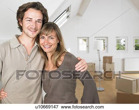 Couple moving into new home smiling. View Large Photo Image Stock Photo - Couple moving into new home smiling.. Fotosearch
