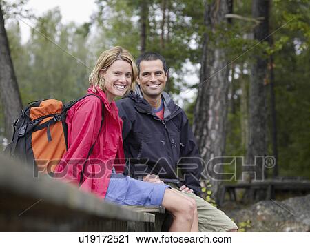 Couple sitting on a dock smiling. View Large Photo Image Stock Image - Couple sitting on a dock smiling.. Fotosearch