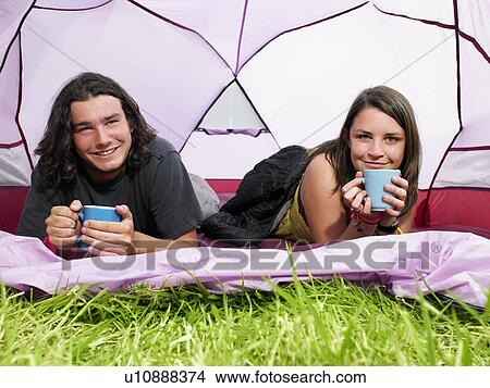 Picture - Couple with mugs in pink tent. Fotosearch