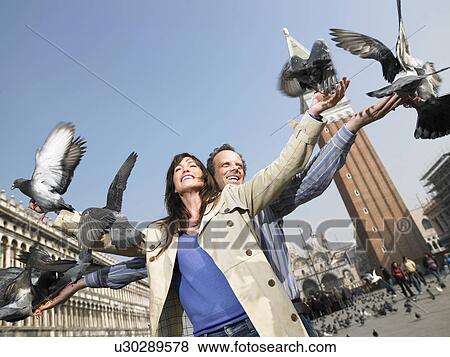 Portrait of couple with pigeons. St Mark's Square, Venice, Italy. View Large Photo Image Stock Photo - Portrait of couple with pigeons. St Mark's Square, Venice, Italy.. Fotosearch