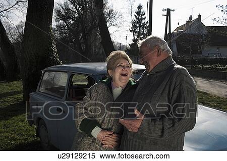 Senior couple leaning on car in countryside, smiling View Large Photo Image Stock Photography - Senior couple leaning on car in countryside, smiling. Fotosearch