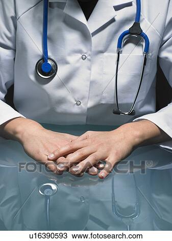 Close up of hands of female doctor at her desk carrying a stethoscope. View Large Photo Image Stock Image - Close up of hands of female doctor at her desk carrying a stethoscope.. Fotosearch