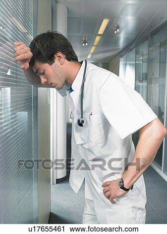 Concerned young doctor in a lobby of a hospital. Low angle close up. View Large Photo Image Stock Image - Concerned young doctor in a lobby of a hospital. Low angle close up.. Fotosearch