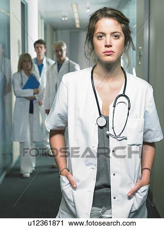 Group of four doctors in a lobby of a hospital. Female doctor in foreground. View Large Photo Image Stock Image - Group of four doctors in a lobby of a hospital. Female doctor in foreground.. Fotosearch