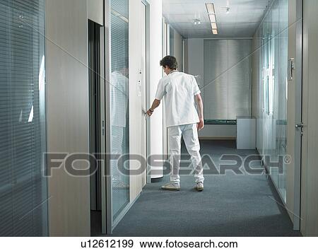 Male doctor opening door in a lobby of a hospital. View Large Photo Image Stock Photo - Male doctor opening door in a lobby of a hospital.. Fotosearch