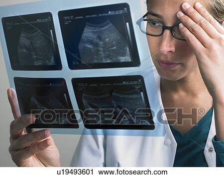 Pensive and concerned female doctor looking at x ray. View Large Photo Image Stock Image - Pensive and concerned female doctor looking at x ray.. Fotosearch