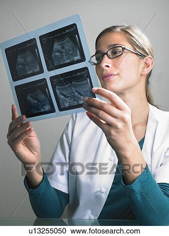 Pensive female doctor looking at x ray. View Large Photo Image Stock Image - Pensive female doctor looking at x ray.. Fotosearch