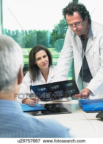 Two doctors in discussion with mature male patient. View Large Photo Image Stock Photo - Two doctors in discussion with mature male patient.. Fotosearch