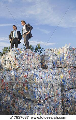 Stock Photo - Business men outdoors at a recycling plant.. Fotosearch