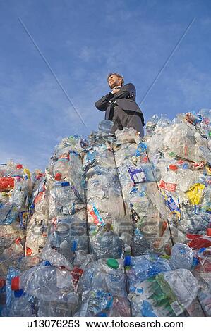 Stock Image - Businessman outdoors at a recycling plant.. Fotosearch
