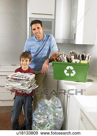 Father and son (6-8) in kitchen with recycling, smiling, portrait View Large Photo Image Stock Photo - Father and son (6-8) in kitchen with recycling, smiling, portrait. Fotosearch