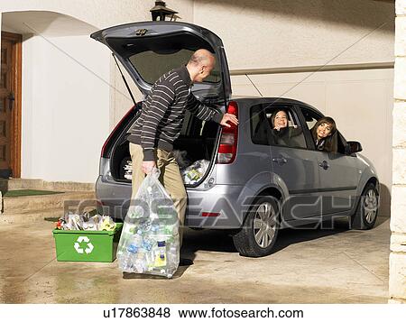 Father holding recycling bag talking to family in car View Large Photo Image Stock Photo - Father holding recycling bag talking to family in car. Fotosearch