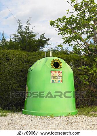 Stock Photo - Green recycling bin by hedge, Alicante, Spain,. Fotosearch
