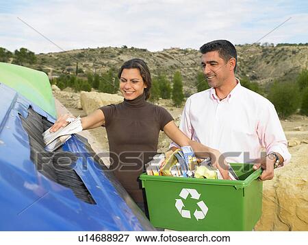 Stock Photo - High angle view of couple placing papers in a recycle bin, husband holding box full of papers, Alicante, Spain,. Fotosearch