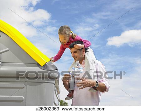 Low angle view of daughter (5-7) on father's shoulders putting plastic bottle in recycling bin, Alicante, Spain, View Large Photo Image Stock Photo - Low angle view of daughter (5-7) on father's shoulders putting plastic bottle in recycling bin, Alicante, Spain,. Fotosearch