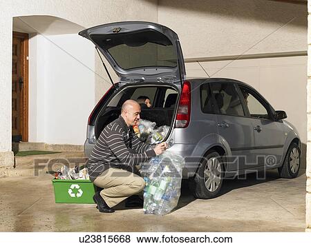 Man loading recycling into car View Large Photo Image Stock Photo - Man loading recycling into car. Fotosearch