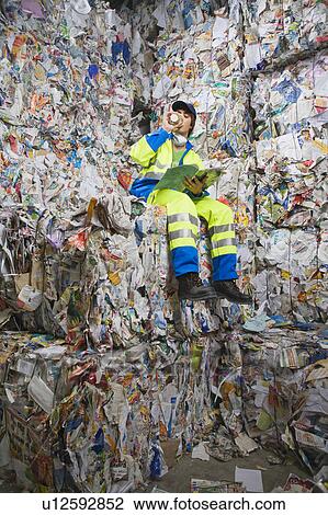 Man reading magazine at a recycling plant. View Large Photo Image Stock Image - Man reading magazine at a recycling plant.. Fotosearch