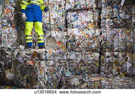 Man with a shovel standing on wall of recycling. View Large Photo Image Picture - Man with a shovel standing on wall of recycling.. Fotosearch