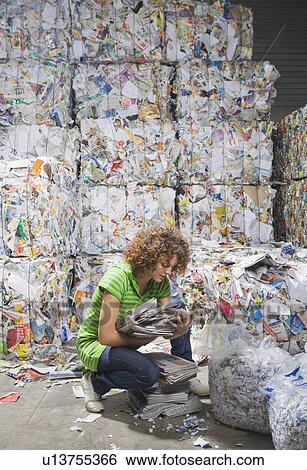 Stock Photograph - Woman sorting through papers at a recycling plant.. Fotosearch