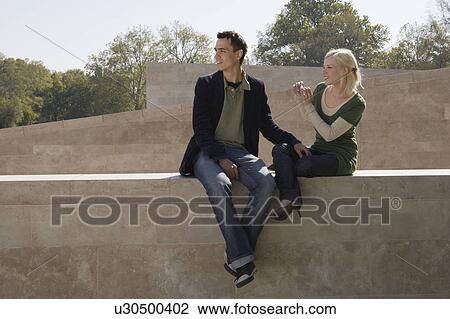 Stock Image - Couple taking a picture outdoors smiling.. Fotosearch