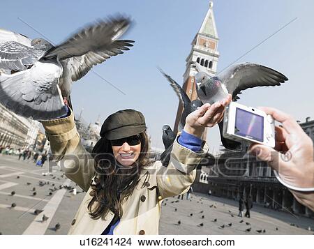 Man taking photograph of woman with pigeons. St Mark's Square, Venice, Italy. View Large Photo Image Picture - Man taking photograph of woman with pigeons. St Mark's Square, Venice, Italy.. Fotosearch