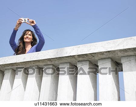 Woman on balcony taking photograph with digital camera. Venice, Italy. View Large Photo Image Stock Image - Woman on balcony taking photograph with digital camera. Venice, Italy.. Fotosearch