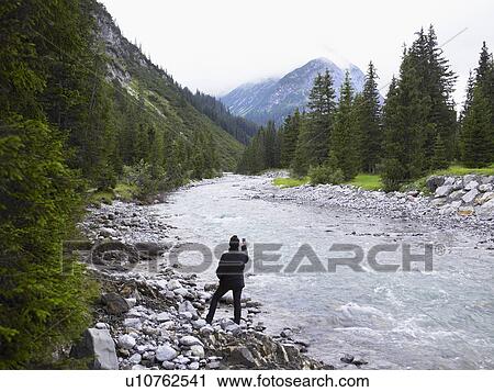 Woman taking pictures of a river. View Large Photo Image Stock Image - Woman taking pictures of a river.. Fotosearch