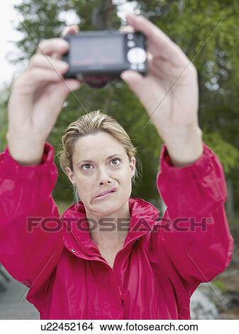 Woman taking self-portrait outdoors. View Large Photo Image Picture - Woman taking self-portrait outdoors.. Fotosearch