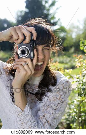 Young bride using digital camera in garden, smiling, close-up View Large Photo Image Stock Photo - Young bride using digital camera in garden, smiling, close-up. Fotosearch