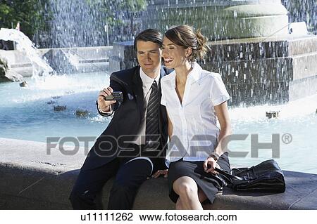 Young couple taking picture together beside fountain. View Large Photo Image Stock Image - Young couple taking picture together beside fountain.. Fotosearch